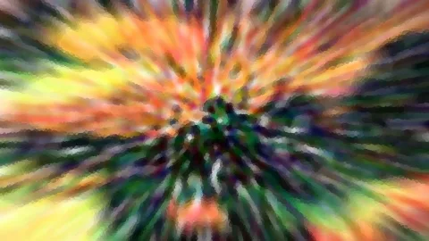 Abstrakte Zoomunschärfe mit farbigen Strahlen in Gelb, Orange, Grün und Violett, die vom dunklen Zentrum nach außen laufen.