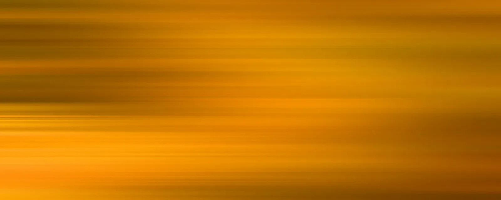 Horizontale, verwischte Streifen in Orange und Gelb, die einen fließenden Farbverlauf bilden.