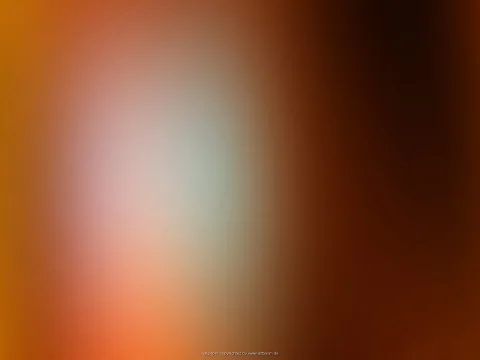 Unscharfer Farbverlauf von Orange über Braun, links ein heller, grünlich-weißer Lichtfleck, rechts fast schwarzbraun.