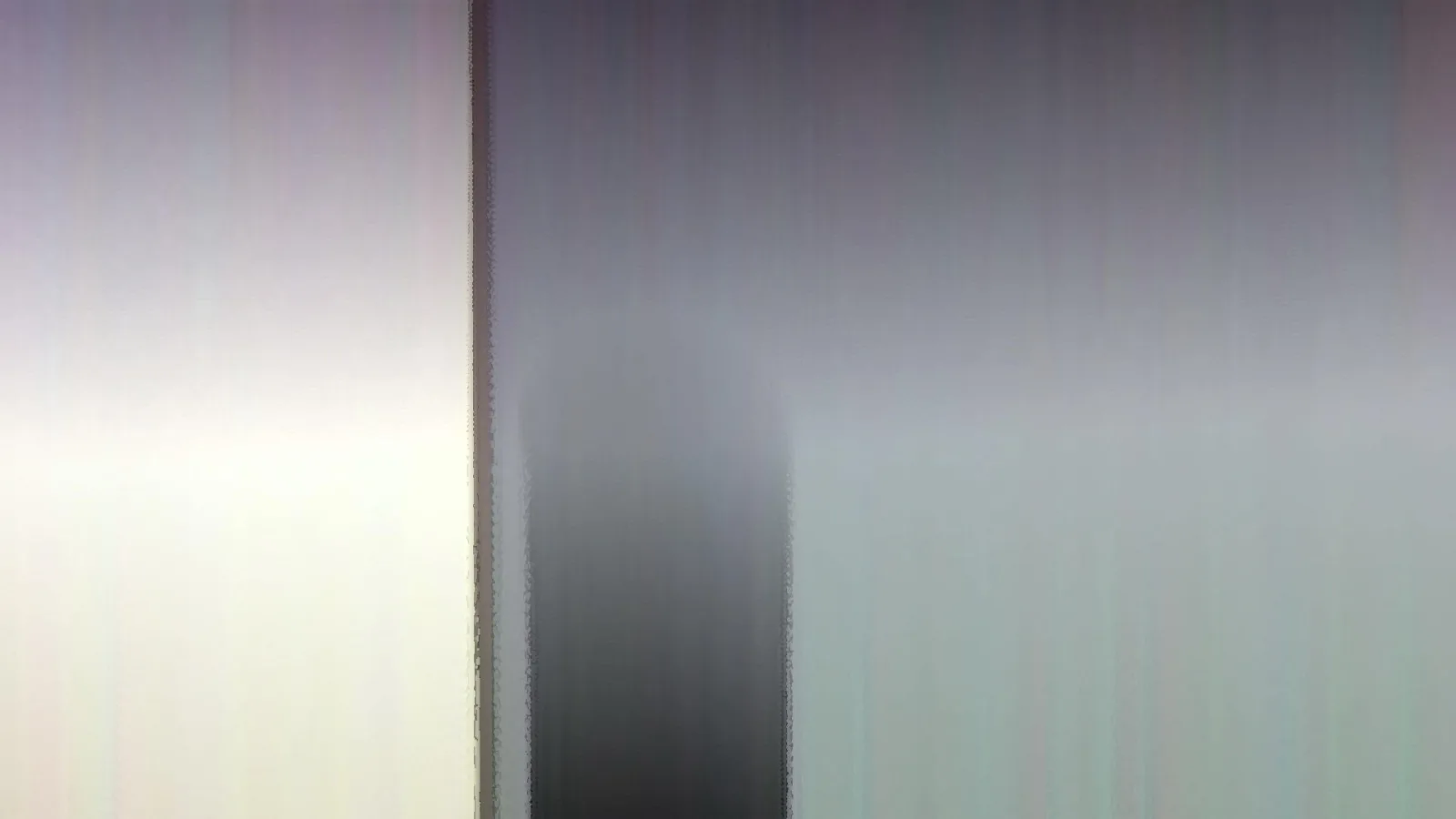 Abstraktes Bild mit vertikalen, verwischten Schlieren in Grau, Weiß und Lavendel, in der Mitte ein dunkler, unscharfer Streifen.