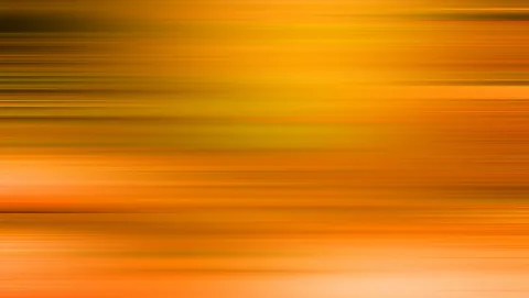 Abstrakte Fläche aus waagerechten, verwischten Streifen in Orange, Gelb und Dunkelbraun, die von links nach rechts zu fließen scheinen.