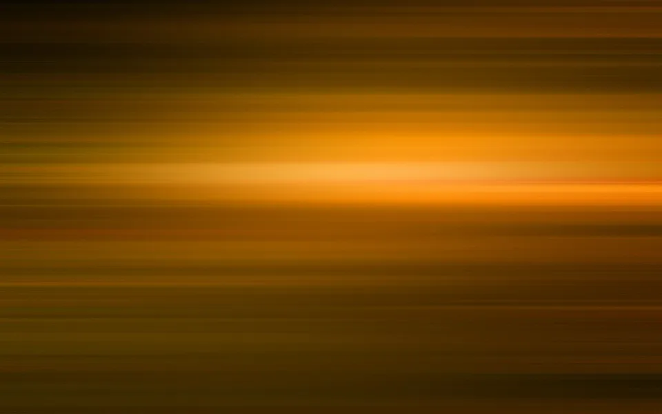 Abstrakte Komposition aus horizontal verwischten Streifen in Gold, Bernstein und Dunkelbraun, mit einem hellen Lichtband in der Bildmitte.