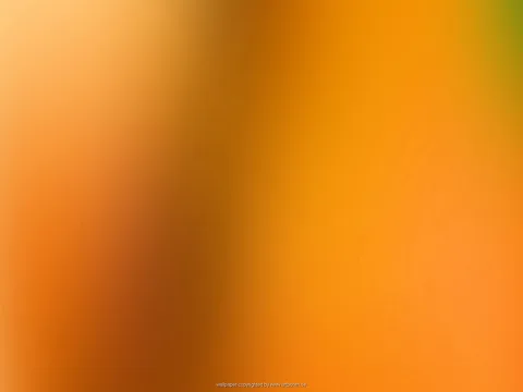 Unscharfer Farbverlauf in Orange und Gelb mit dunkleren braunen Streifen links der Mitte und einem grünlichen Fleck oben rechts.