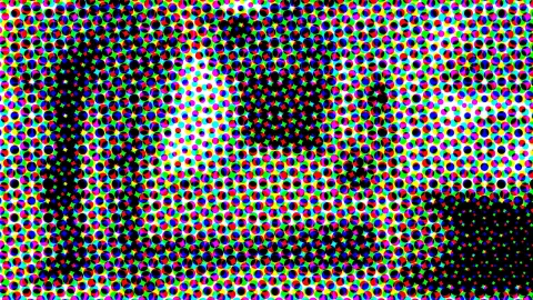 Dichtes Raster aus farbigen Punkten in Rot, Grün, Blau, Gelb und Magenta, dazwischen größere schwarze Flächen, die eine verschwommene Form bilden.