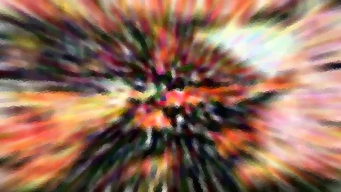 Bunte, radial verwischte Farbstrahlen laufen von einem hellen Zentrum in der Bildmitte nach außen.