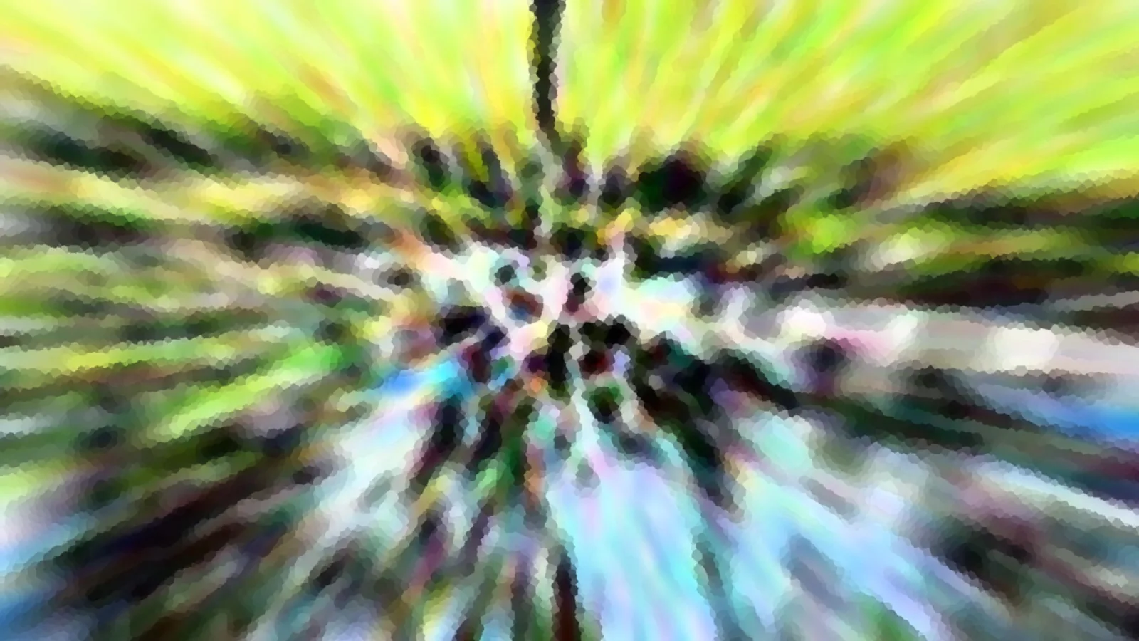 Abstrakte, stark verwischte Aufnahme mit radialen Streifen, die von einem dunklen Zentrum nach außen laufen; oben gelbgrün, unten bläulich und weiß.