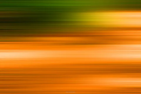 Abstrakte horizontale Streifen aus Grün oben und Orange unten, mit hellen gelben Lichtbahnen im oberen rechten Bereich.