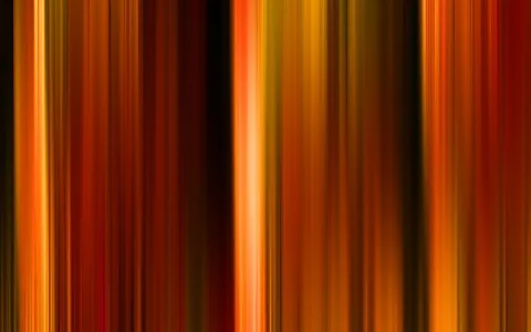 Abstraktes Bild aus senkrechten, unscharfen Streifen in Orange, Rot und Gelb, dazwischen dunkle Bahnen.