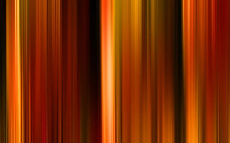 Abstraktes Bild aus senkrechten, unscharfen Streifen in Orange, Rot und Gelb, dazwischen dunkle Bahnen.
