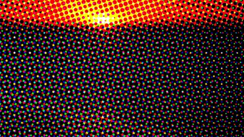 Abstraktes Muster aus Halbtonpunkten: oben leuchtend rot und gelb, darunter bunte Pixelpunkte auf Schwarz.