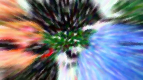 Abstrakte Aufnahme mit radialer Zoomunschärfe: Farbstreifen in Orange, Grün, Rot und Blau laufen von einem dunklen, grünlich getönten Zentrum nach außen.