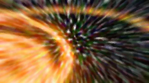 Abstraktes Bild mit radialer Bewegungsunschärfe in Orange, Grün und Schwarz, die Streifen laufen zur Bildmitte.
