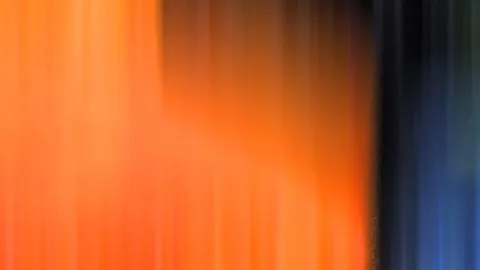 Abstrakte Bewegungsunschärfe mit senkrechten Schlieren: links leuchtendes Orange, rechts ein dunkler Übergang ins Blau.