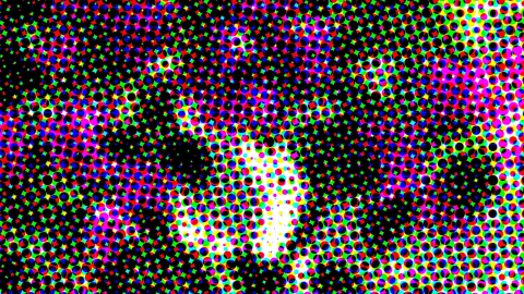 Abstraktes Muster aus farbigen Punkten in Rot, Grün, Blau und Magenta auf schwarzem Grund, in der Bildmitte ein helles Leuchten.