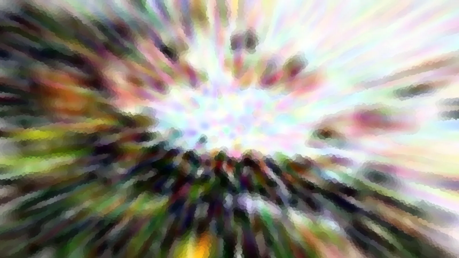 Abstrakte Zoomunschärfe in Regenbogenfarben, Streifen laufen von einem hellen Zentrum nach außen und sind pixelig aufgelöst.