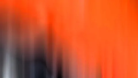 Verwischte vertikale Schlieren in Orange, links unten dunkles Grau und helles Weiß.