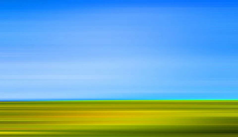 Abstrakte Aufnahme mit horizontalen Streifen: oben ein kräftiges Blau des Himmels, unten gelbgrüne Wiese, getrennt durch eine schmale Horizontlinie.