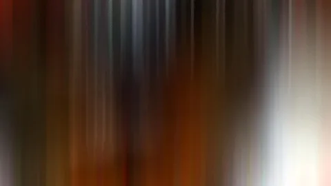 Abstrakte, vertikal verwischte Farbstreifen in Braun, Orange und Weiß, rechts hell, links dunkler.