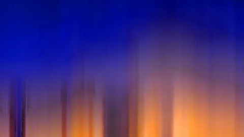 Abstrakte, vertikal verwischte Farbflächen: oben tiefes Blau, unten warmes Orange mit hellen Lichtstreifen.