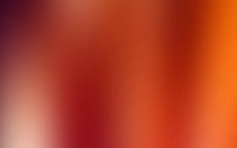 Unscharfer Verlauf von dunklem Weinrot über Rot bis zu hellem Orange, links unten ein heller Fleck.