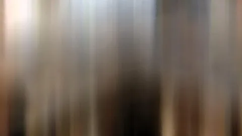 Verschwommene vertikale Streifen in Grau, Beige und Braun, links oben heller, in der Mitte dunkler.