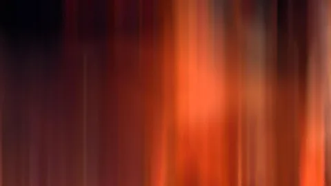 Abstrakte, vertikal verwischte Schlieren in Orange, Rot und Dunkelbraun, rechts heller leuchtend, links dunkel.