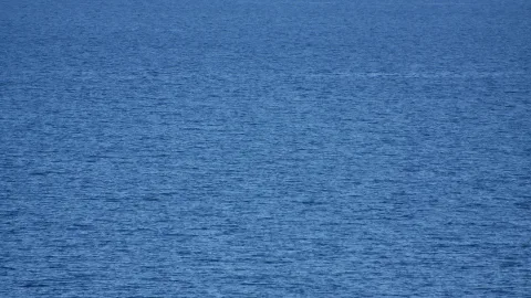 Tiefblaue Wasseroberfläche mit feinen Wellen und leichtem Glitzern, ohne sichtbaren Horizont.