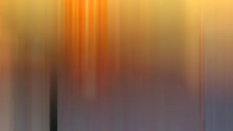Abstrakte Komposition aus vertikalen, verwischten Streifen in Orange, Gelb und Violett, links unten ein dunkler senkrechter Balken.