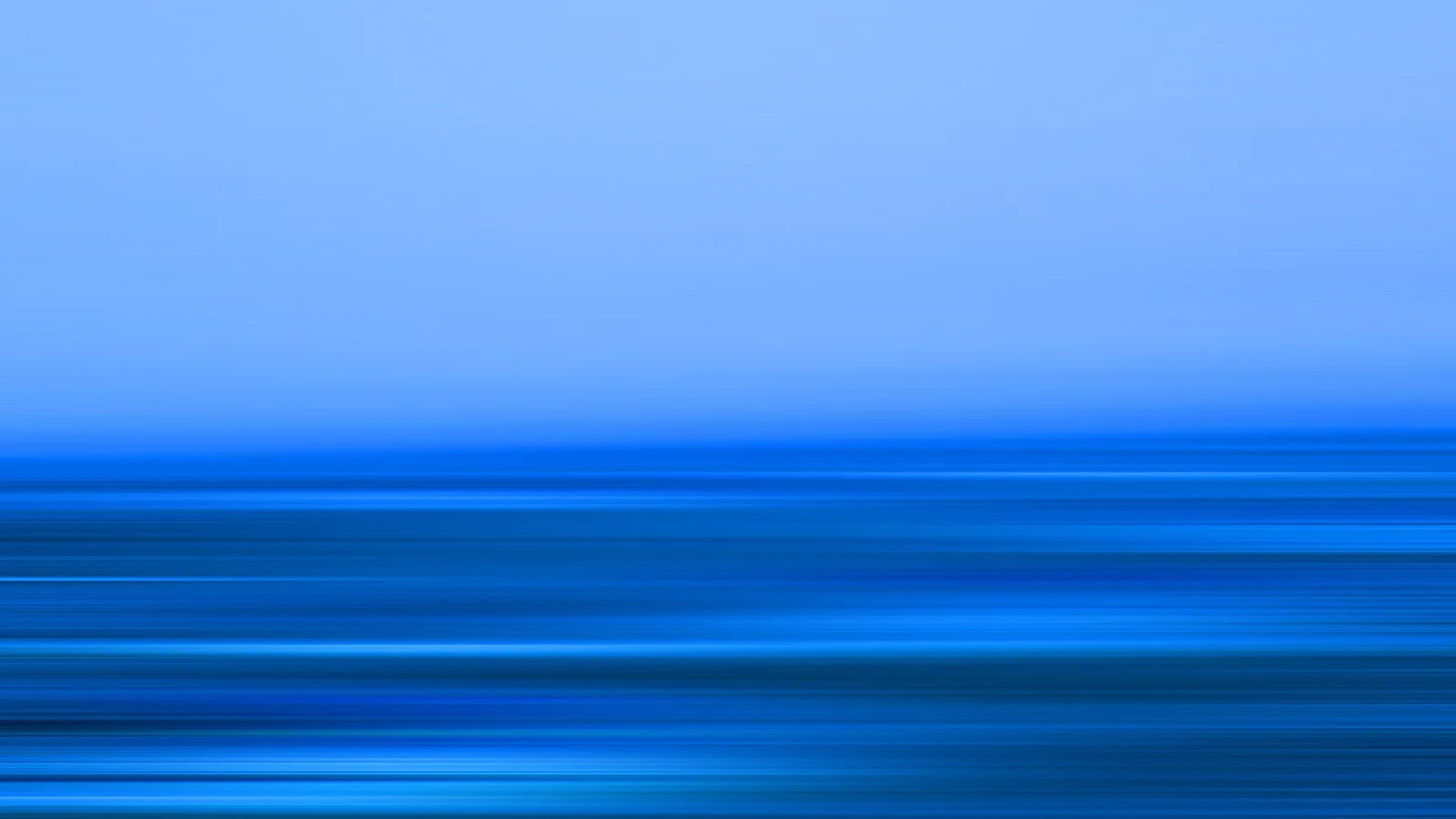 Horizontale, verwischte Linien in verschiedenen Blautönen. Oben ein heller, nahezu gleichmäßiger Himmelsverlauf, unten dichte, horizontale Streifen wie bei einer Bewegungsunschärfe.