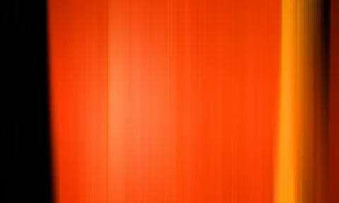 Vertikale orangefarbene Streifen mit weichem Verlauf, links schwarzer Rand, rechts ein gelber Lichtbalken.