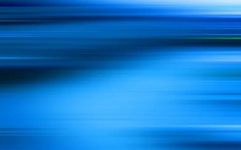 Horizontal verwischte Streifen in Blau- und Türkistönen, oben dunkler, zur unteren Bildhälfte hin heller, mit einem schmalen grünen Akzent rechts oben.
