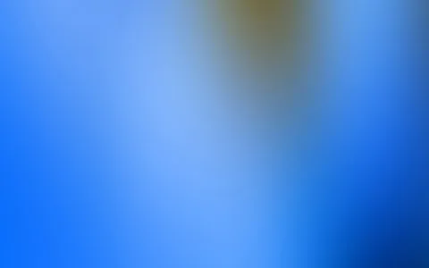 Unscharfer Farbverlauf in Blau, oben in der Mitte ein verwaschener, bräunlich-gelber Lichtfleck.