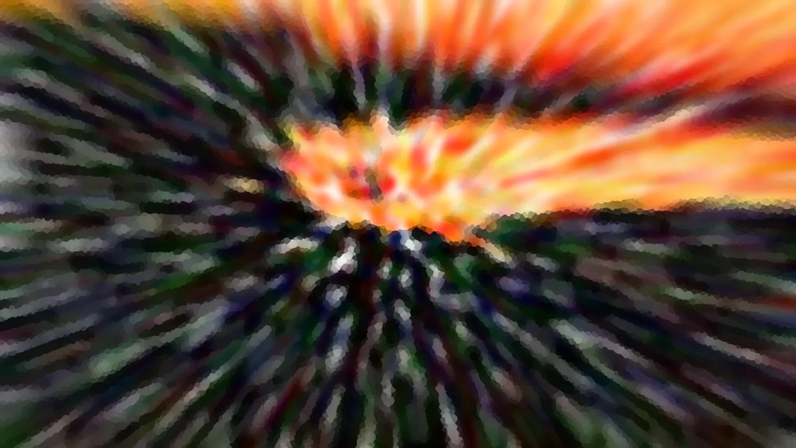 Abstrakte Radialunschärfe mit orangefarbenem Himmel über dunklen Bäumen und Hügeln