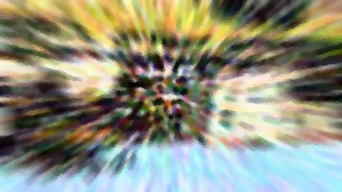 Abstraktes Bild mit radialem Zoom-Effekt: Farbige Streifen in Grün, Gelb, Pink und Violett laufen von einem dunklen Zentrum nach außen, unten zeigt sich helles Blau.