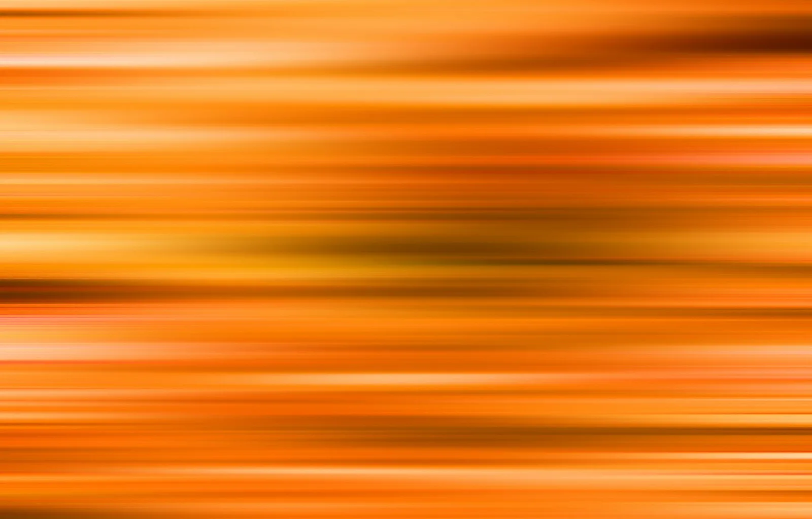 Abstrakte horizontale Streifen in Orange, Gelb und Braun, weich verschwommen, wie bei einer schnellen Wischbewegung.