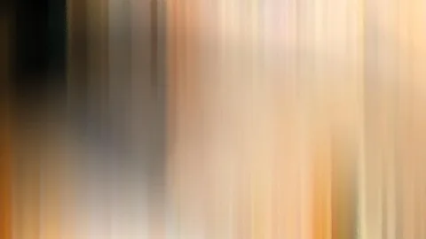Abstrakte, vertikal verwischte Streifen in Orange, Beige und Braun, links dunkler, rechts heller.