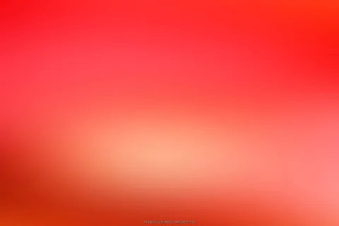 Unscharfer Verlauf von leuchtendem Rot über Rosa bis Orange, in der Mitte ein heller, warmer Schimmer.