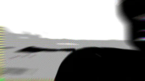 Abstrakte Schwarzweiß-Aufnahme mit weißem Himmel oben, grauer Fläche und einer großen schwarzen Form rechts unten, dazu Moiré-Muster und farbige Schlieren am Rand.