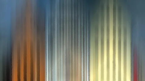 Abstraktes Bild aus vertikal verwischten Streifen in Blau, Orange, Grau und Creme, von links dunkel bis rechts hell verlaufend.