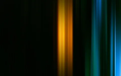 Dunkler Hintergrund mit senkrechten, verwischten Lichtstreifen: ein gelb-oranges Band in der Mitte und ein blau-grünes Bündel am rechten Rand.