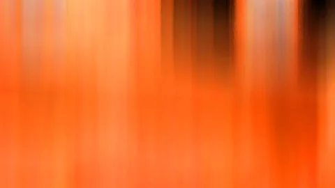 Abstrakte Aufnahme mit vertikalen Streifen in Orange, Hellgelb und Dunkelbraun, die nach oben und unten verwischen.