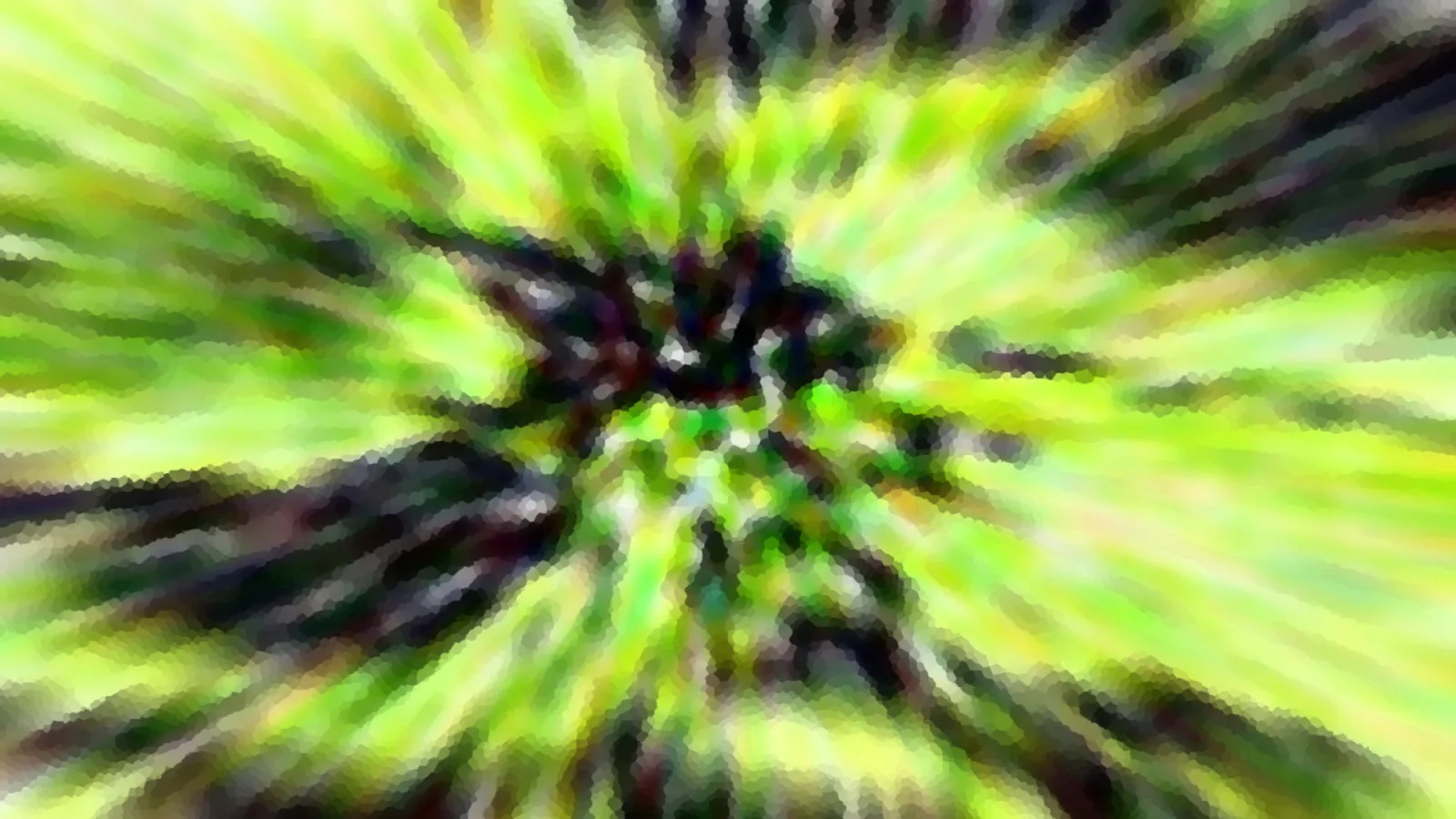 Stark verwischte Aufnahme mit grünen und gelben Schlieren, die radial von einem dunklen Zentrum nach außen laufen.