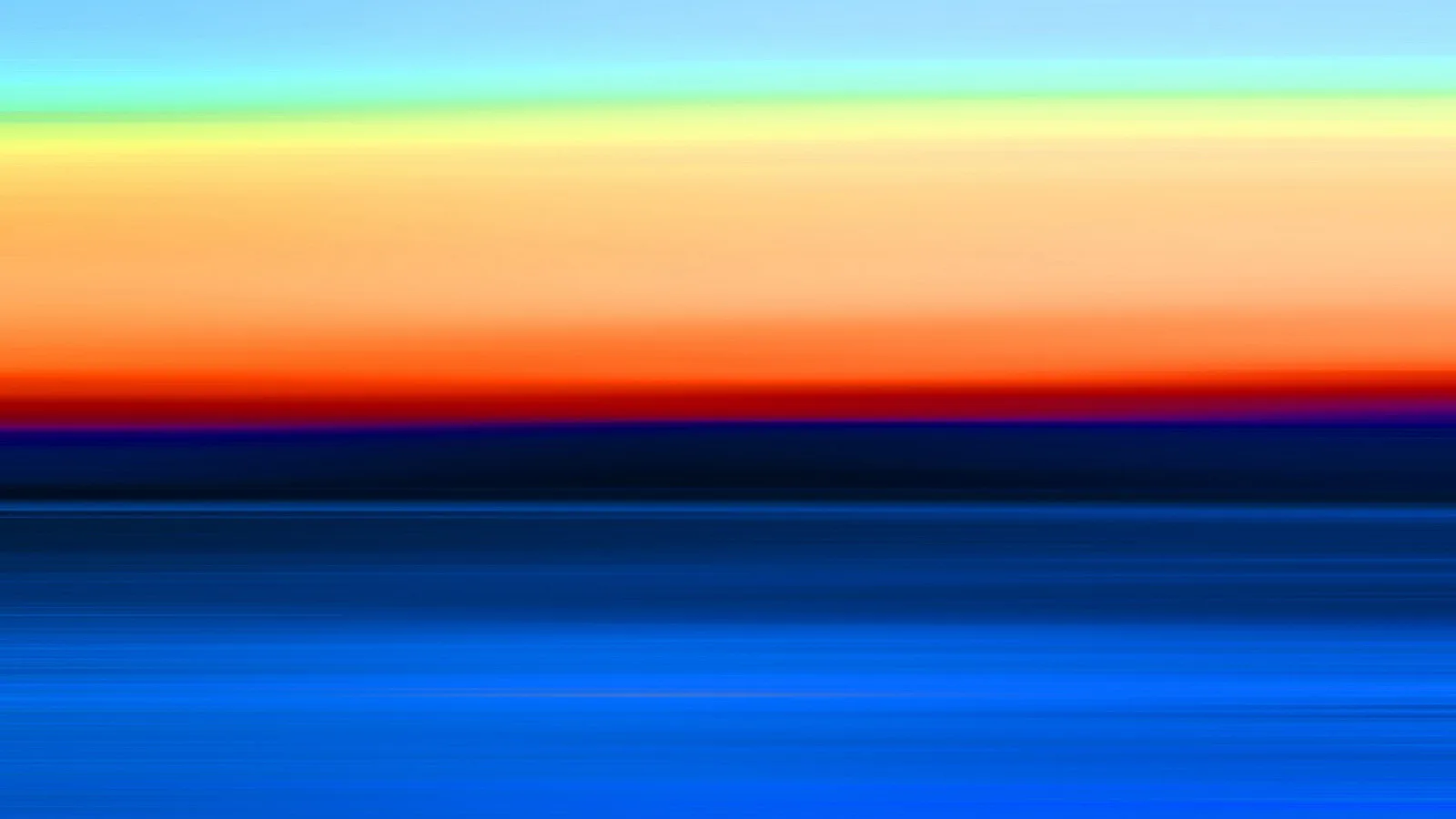 Horizontal verwischte Streifen von hellblau über Grün, Gelb und Orange bis zu Rot und tiefem Blau, wie eine Bewegungsunschärfe.