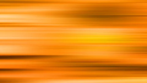 Horizontal verwischte Streifen in Orange, Gelb und Braun, die hellste Stelle liegt rechts der Mitte.