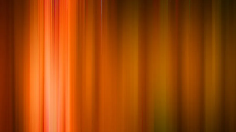 Vertikal verlaufende, unscharfe Streifen in Orange, Rot und Ockergelb, die von links hell leuchtend nach rechts dunkler werden.