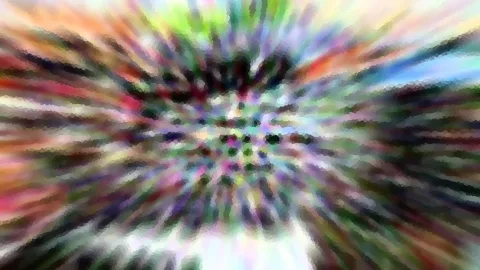 Abstraktes Bild mit radialer Bewegungsunschärfe in Regenbogenfarben, im Zentrum ein Muster aus dunklen Punkten.