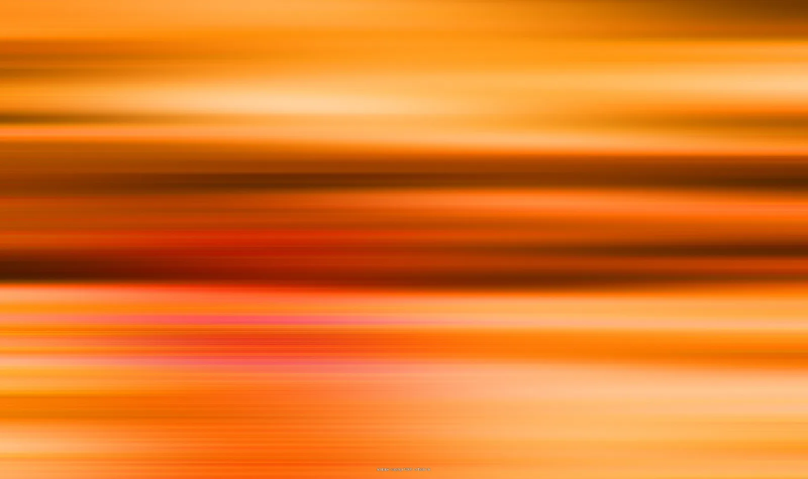Horizontal verwischte Streifen in Orange, Gelb und Rot, dunklere braune Bänder im mittleren Bereich, helle Schlieren am unteren Rand.