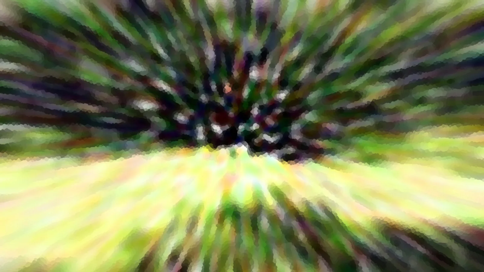 Radial verwischte Aufnahme mit grünen und gelben Schlieren, im Zentrum dunkel.