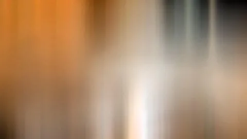 Abstrakte, vertikal verwischte Streifen in Orange, Weiß und Grau mit einem hellen Lichtzentrum in der Mitte.