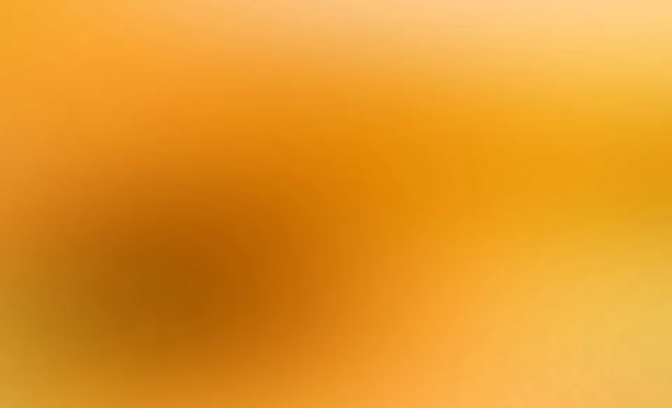 Unscharfer Farbverlauf in Orange und Gelb mit einem dunkleren braunen Schwerpunkt links der Mitte.